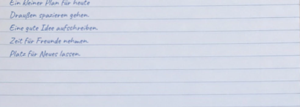 Nahaufnahme der an den Notizbuchlinien ausgerichteten Caveat-Handschrift